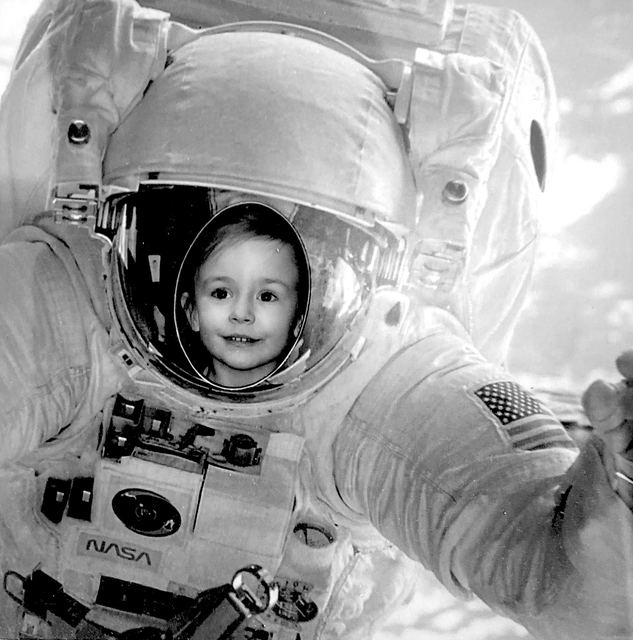 Sonia as a small child, her face in the visor of an astronaut suit